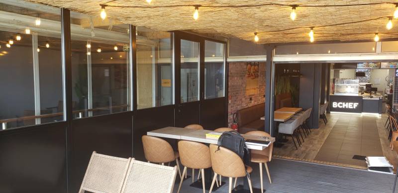 Conception sur mesure de menuiseries vitrées en aluminium noir pour un restaurant à Canet-en-Roussillon